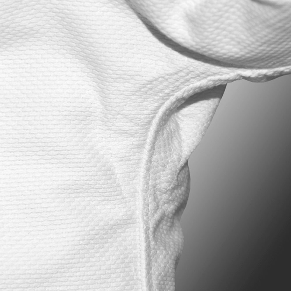 Macro shot of heavy-duty reinforced stitching in the underarm area of the QTBU-001 wholesale BJJ gi